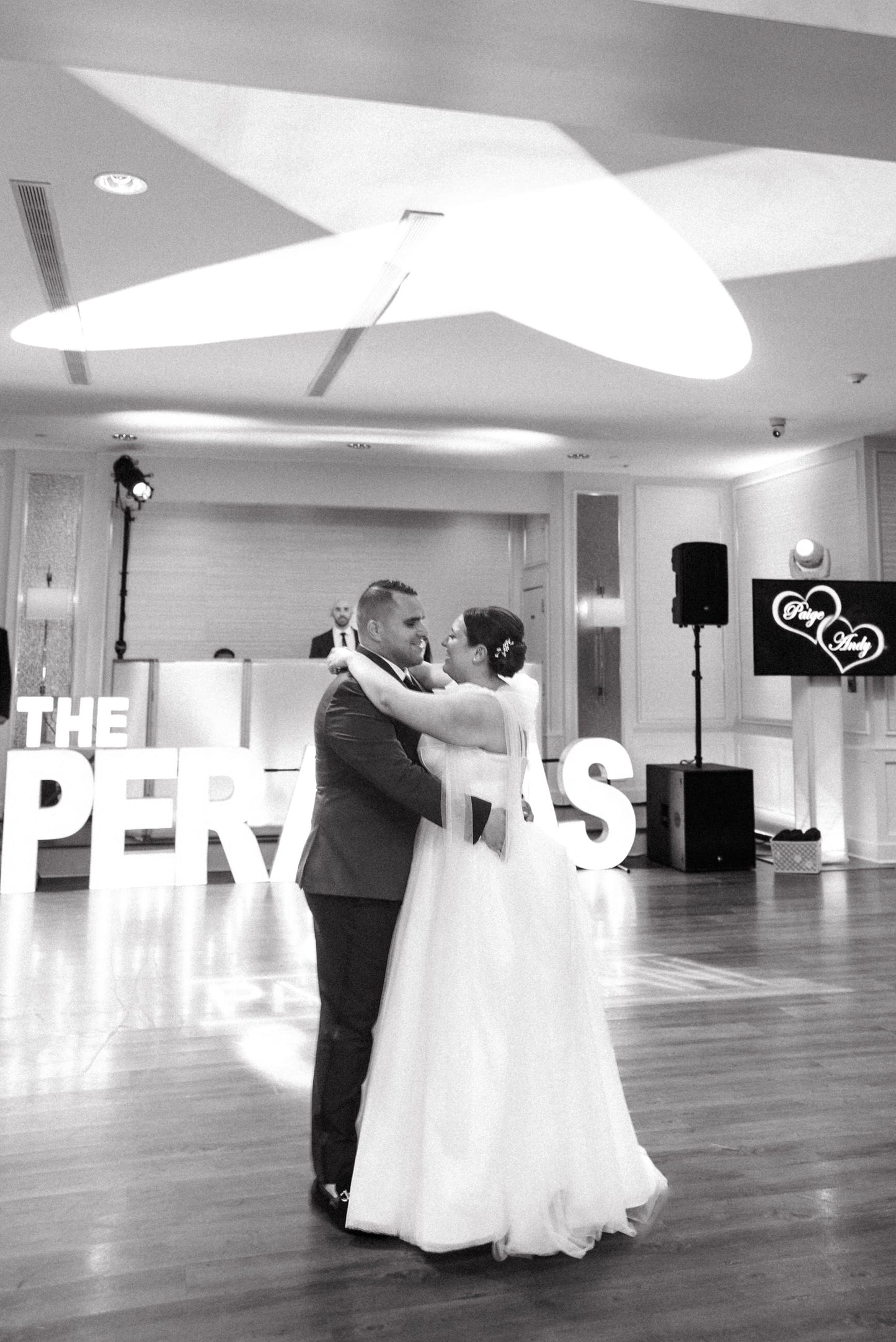 bride and groom dance with bride wearing tulle shoulder bows on her spaghetti strap bridal gown