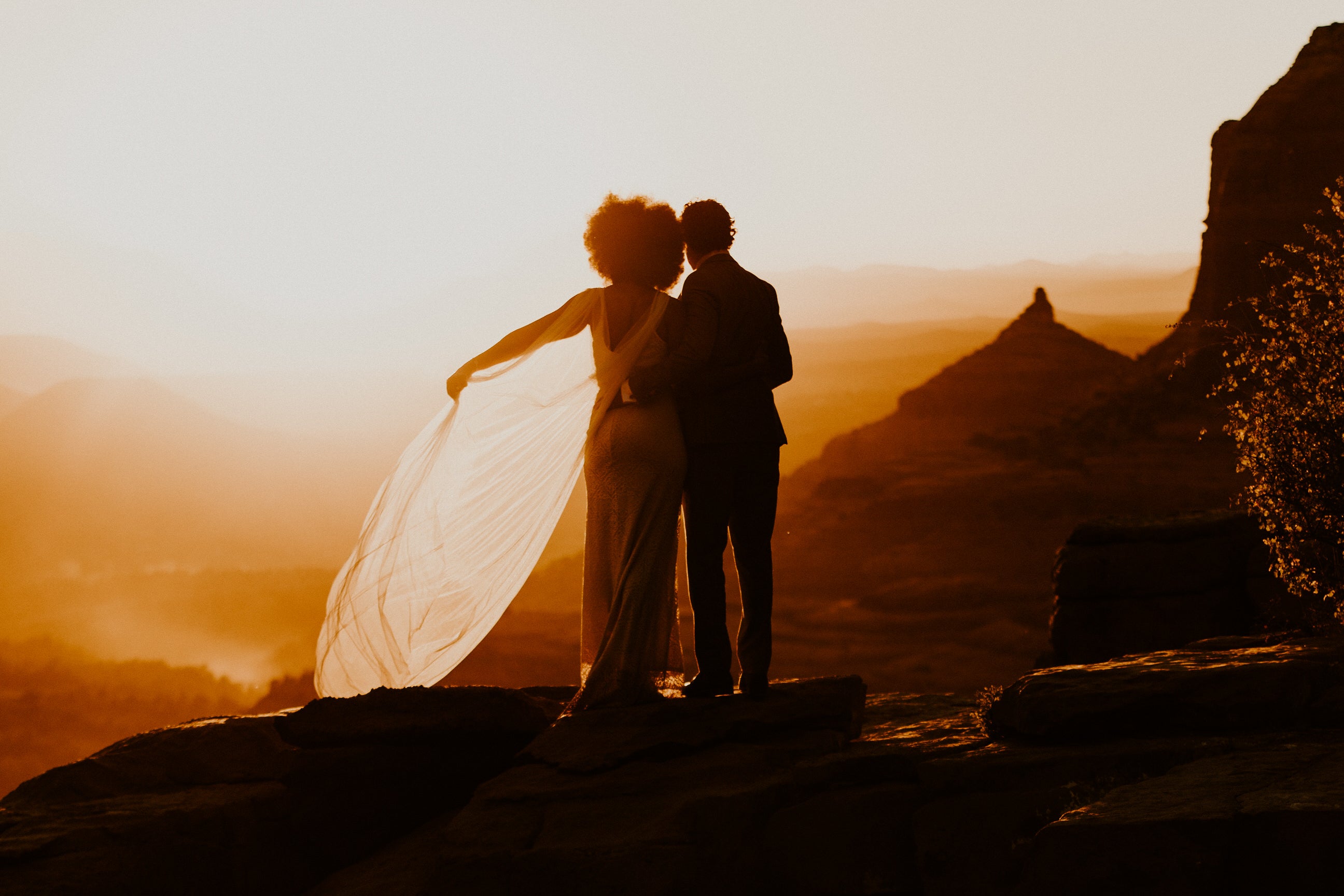 sunset Grand Canyon wedding with bride wearing draped wedding cape veil in ivory