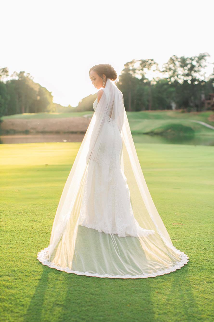 timeless cathedral length bridal veil with lace trim under the bride's curled updo with golf course setting