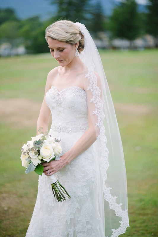 bride in knee length long lace bridal veil with updo and sweetheart strapless gown