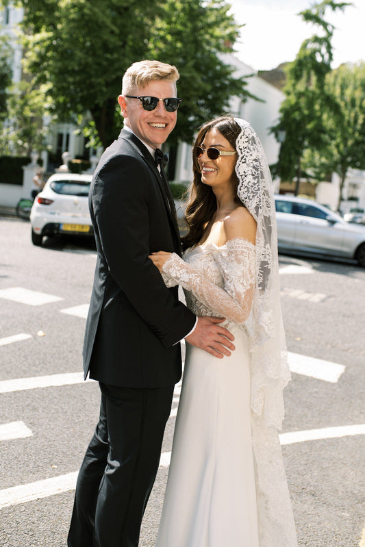 stunning UK bride and groom with bride in lace mantilla veil and sunglasses in London streets