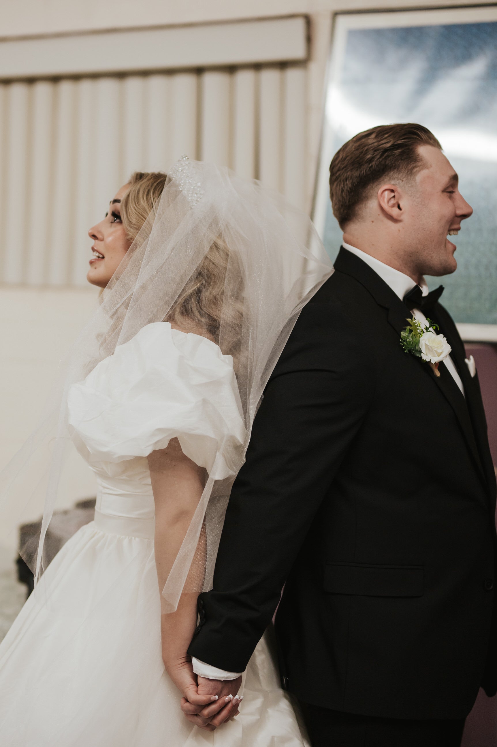 Wedding couple holding hands exchanging vows with puff sleeve bridal seperates made from the bride