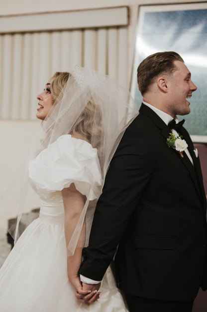 Wedding couple holding hands exchanging vows with puff sleeve bridal seperates made from the bride