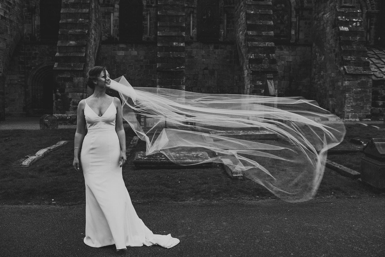 Load video: bride and groom in desert with bride wearing updo with long simple light ivory bridal veil