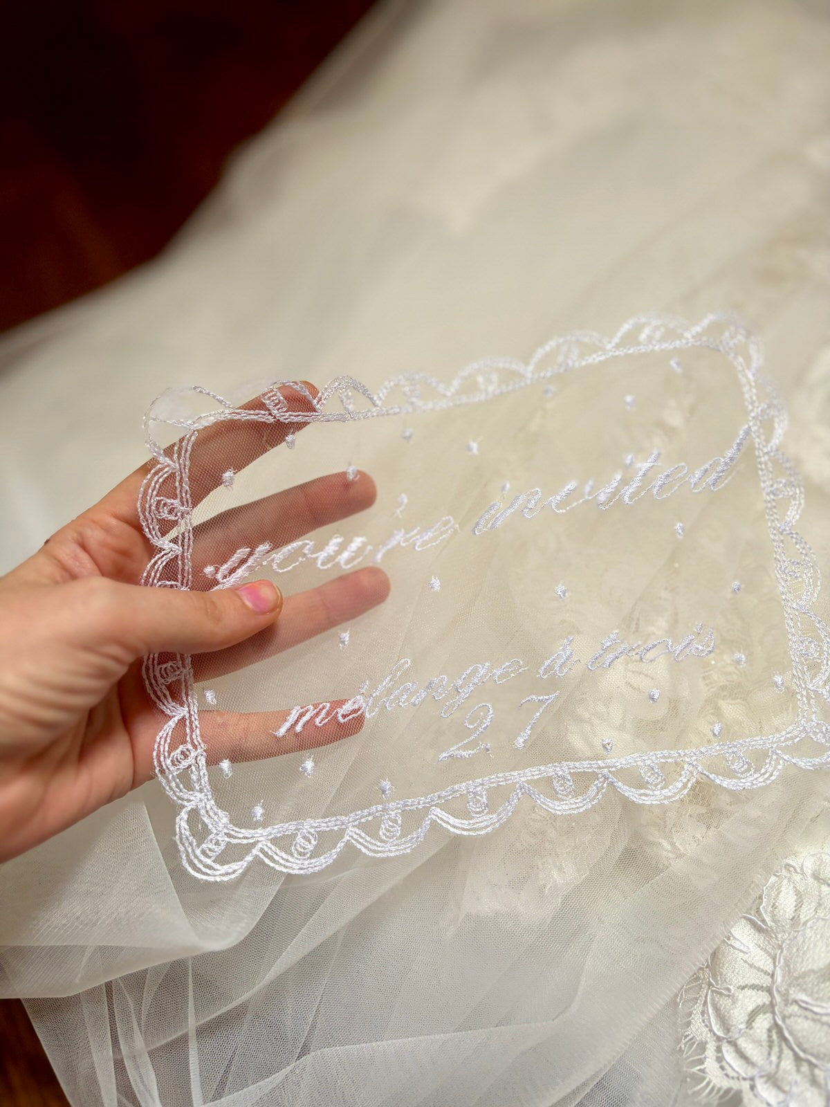 Hand holding  lace doily with embroidered text for milestone business opening