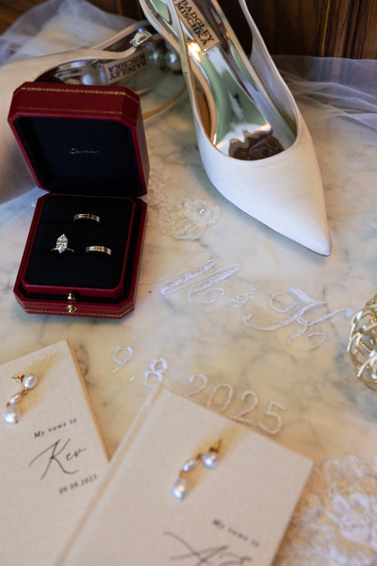 Silver engagement rings in a red box with a white bridal heel and wedding embroidered veil in white