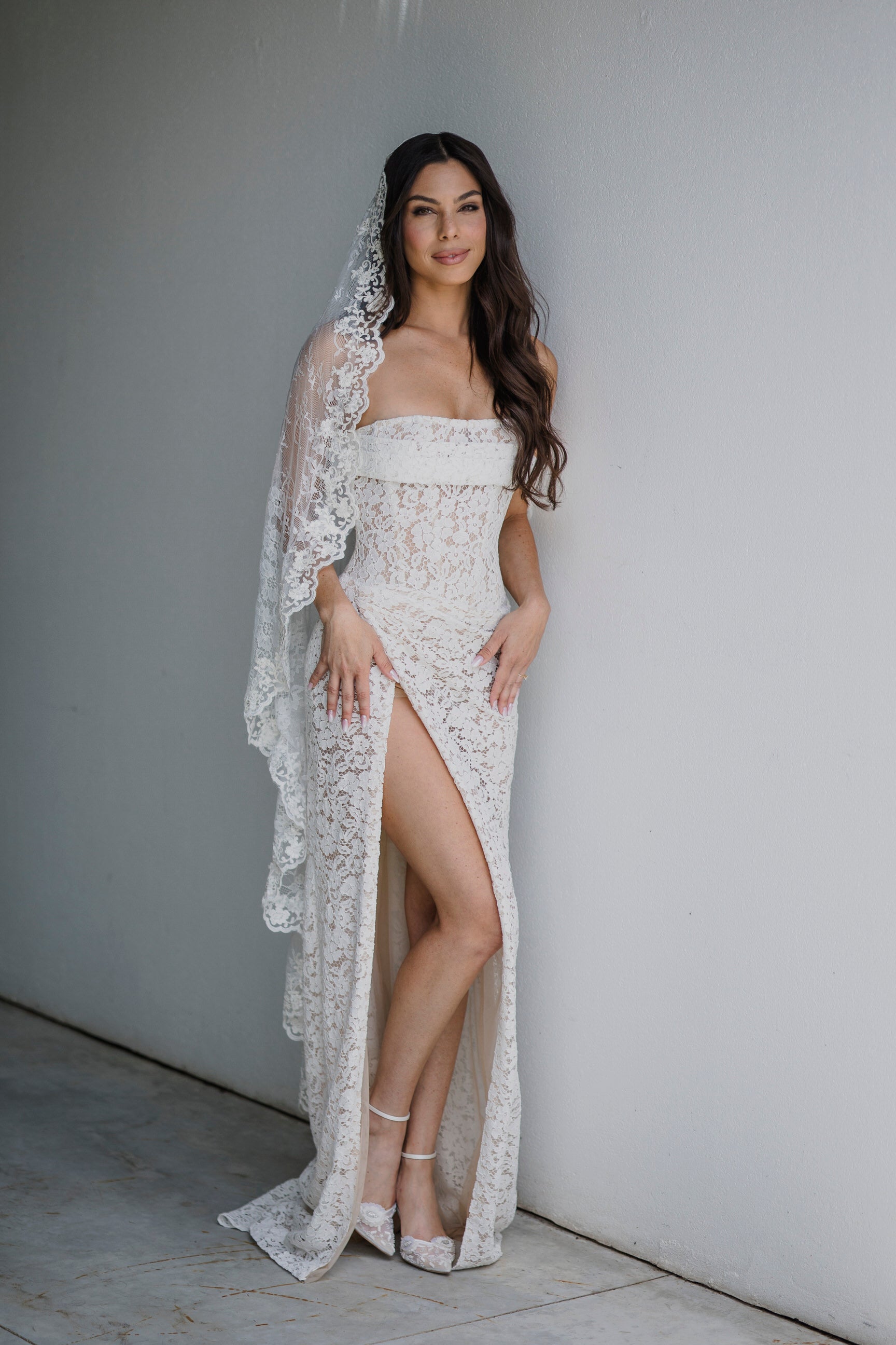 sultry slit wedding dress and long traditional lace bridal veil with corded scallop edges