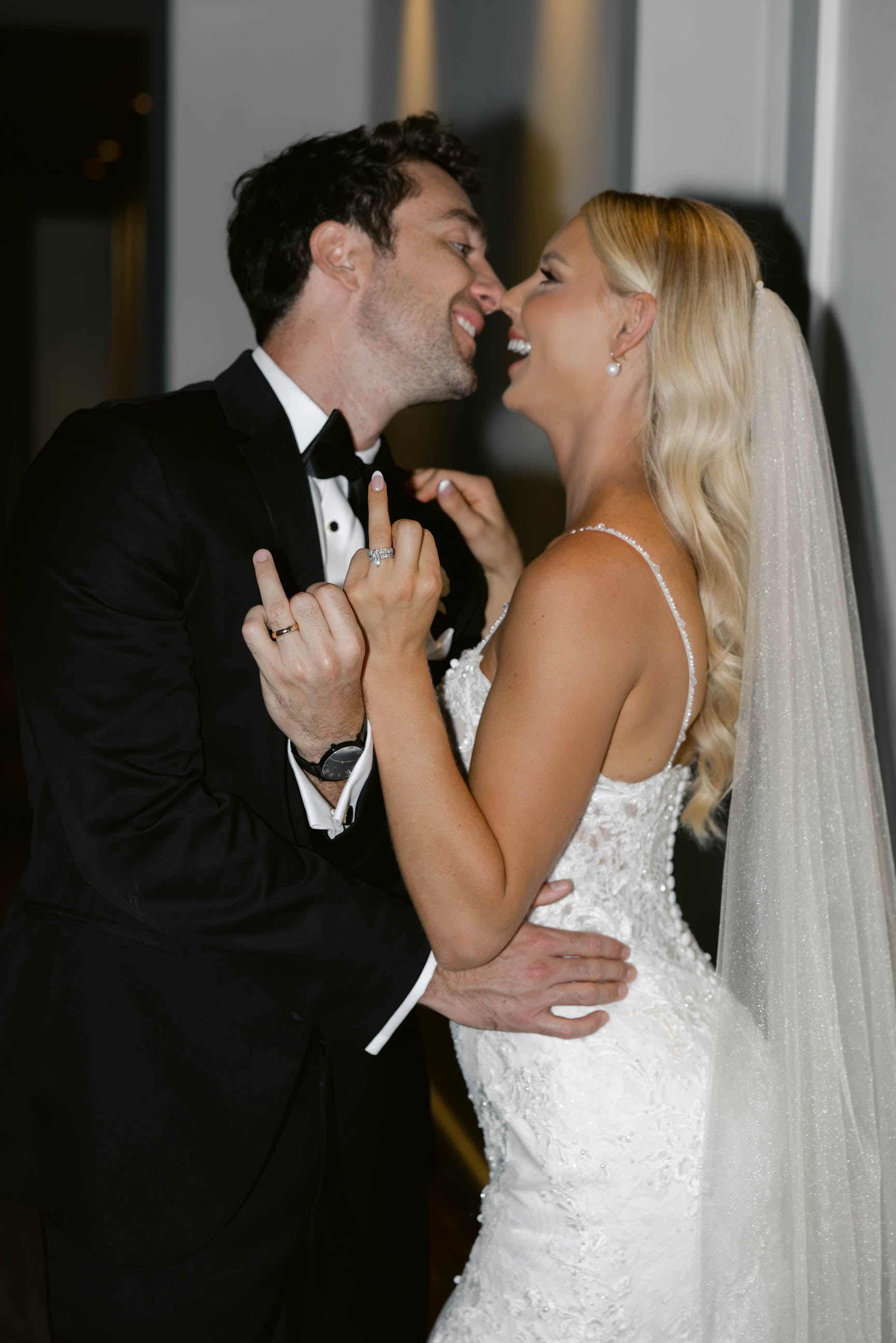 glam old Hollywood style loose waves with glimmer bridal veil as bride embraces groom