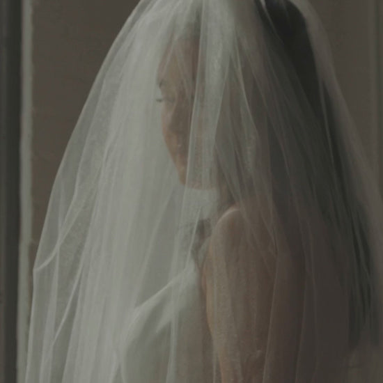 puffy two layer cathedral length wedding veil in bride's downdo curled hair