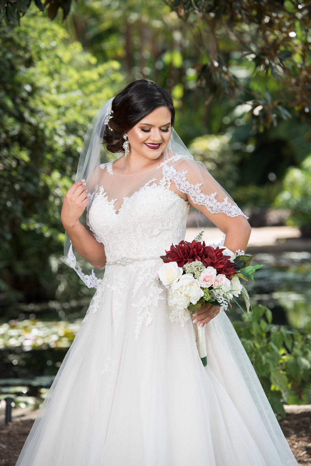 winter inspiration in short waist length wedding veil and with red bouquet