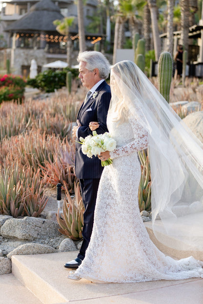 flowy downdo on bride with blusher drop wedding veil over fae as father walks her down aisle