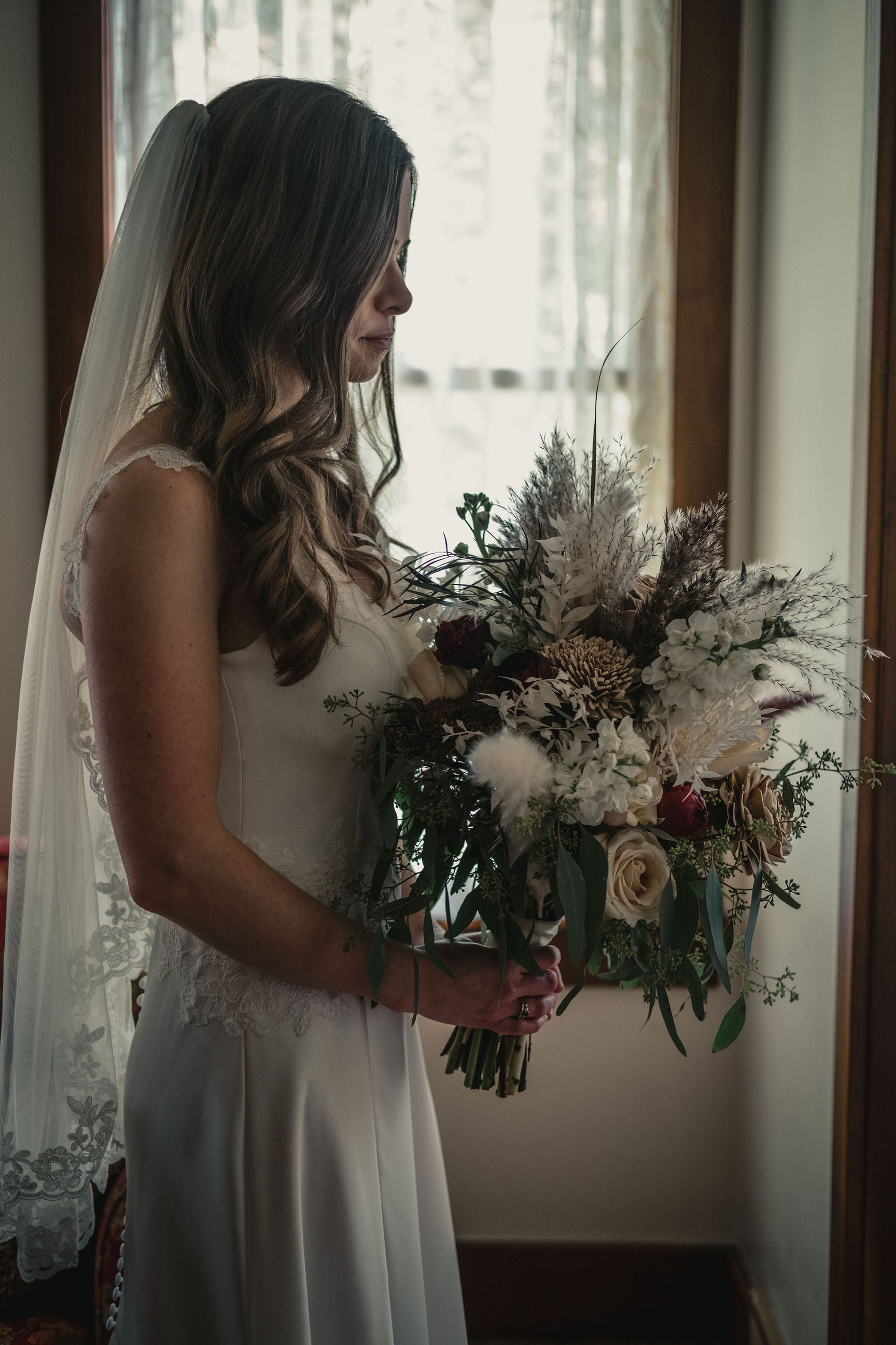 lace edge fingertip bridal veil in bride's all down hairstyle and lace appliqué at waistline of dress